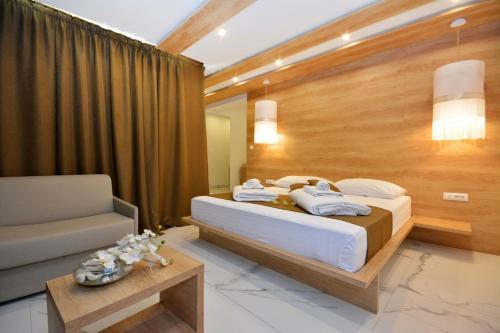a bedroom with a large bed and a chair at Hotel San Antonio in Podstrana