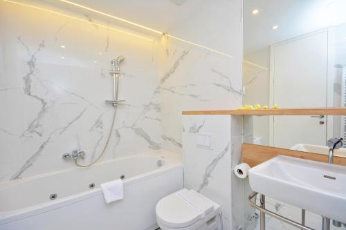 a bathroom with a sink and a tub and a toilet at Hotel San Antonio in Podstrana