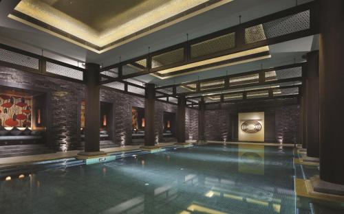 a swimming pool in a building with a brick wall at Four Seasons Hotel Hangzhou at West Lake in Hangzhou