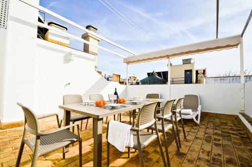 een patio met een tafel en stoelen op een balkon bij NineSuites in Sevilla