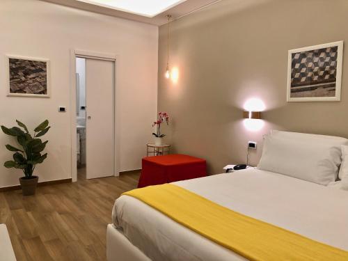 a bedroom with a white bed and a red stool at Residenza Madonna in Pompei