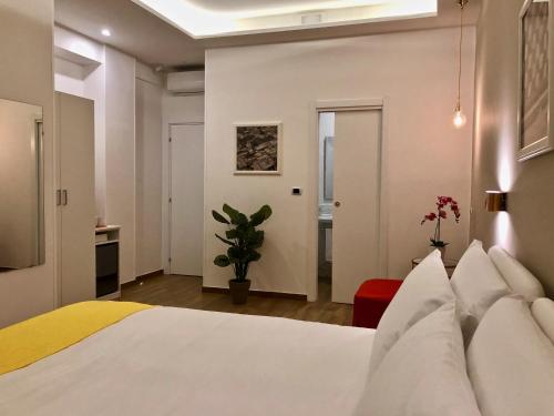 a bedroom with a white bed and a plant at Residenza Madonna in Pompei