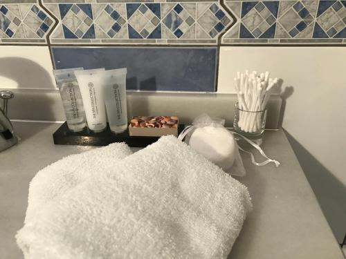 a bathroom counter with two white towels and toothbrushes at B&B Finca La Luna Azul in Coín