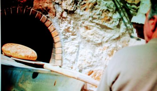 a person is making bread in a brick oven at Petrochori ApartHotel in Petrochori