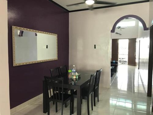 a dining room with a table and chairs and a mirror at Safwa Homestay Bagan Serai in Bagan Serai