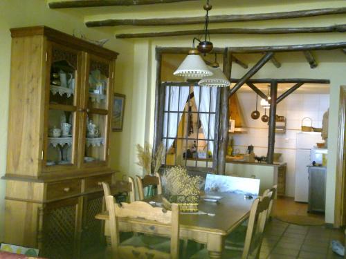 a dining room with a table and a kitchen with a chandelier at CASA MIRADOR DE MARIA in Capileira