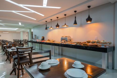 a buffet line with tables and chairs in a restaurant at Hotel Sauípe in Cascavel