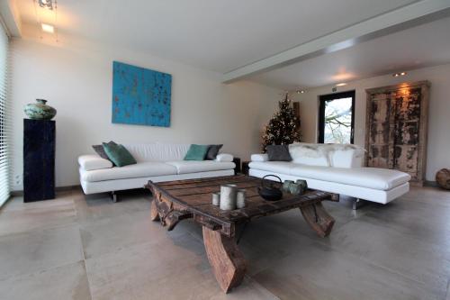 Sala de estar con 2 sofás blancos y mesa de centro en ARVAK HEYD (DURBUY) en Heyd