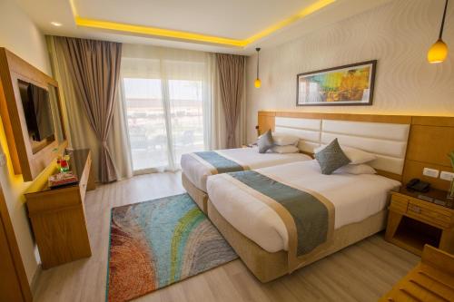a hotel room with a large bed and a television at Pickalbatros Aqua Blu Sharm El Sheikh in Sharm El Sheikh