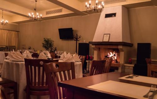 a dining room with tables and a fireplace at Hotel Garden Club in Braşov