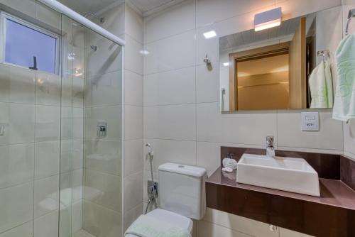 a bathroom with a toilet and a sink and a shower at Hotel Sauípe in Cascavel