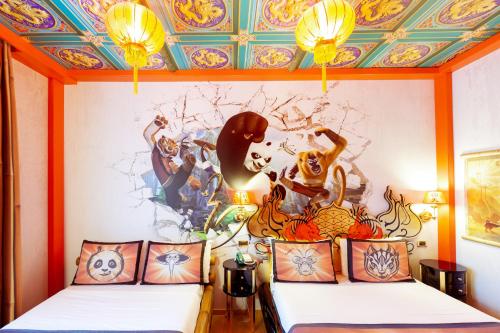 two beds in a room with a painting on the wall at Gardaland Hotel in Castelnuovo del Garda