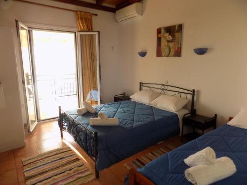 a bedroom with two beds and a balcony at Villa Elli Panoramic View in Ipsos