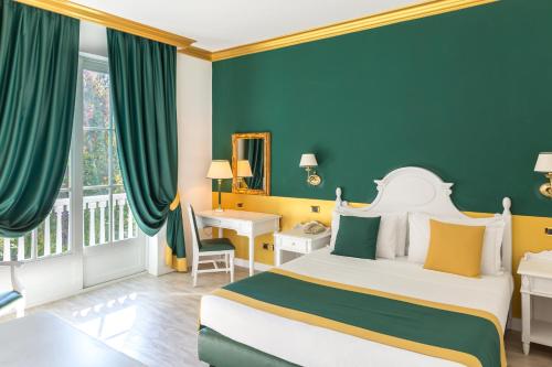 a hotel room with a bed and a desk and a window at Gardaland Hotel in Castelnuovo del Garda
