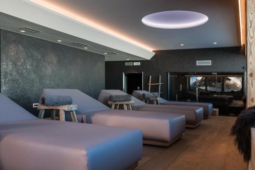 a waiting room with couches and stools at Sunny Valley Mountain Lodge in Bormio