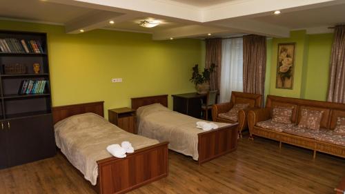 クラースナヤ・ポリャーナにあるApartment on Volokolamskayaのベッド2台とソファが備わるホテルルームです。