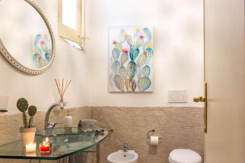 ファザーノにあるpalazzinApuliaのバスルーム(ガラスの洗面台、トイレ付)