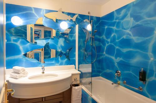 a bathroom with a sink, mirror, and bathtub at Gardaland Hotel in Castelnuovo del Garda