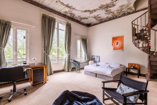 Cette chambre comprend un lit, un bureau et des chaises. dans l'établissement Veeve - Charming Townhouse near Parc Montsouris, à Paris