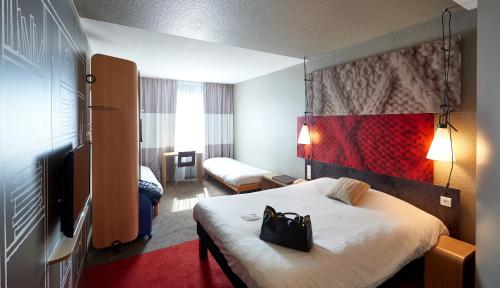 A bed or beds in a room at ibis Cholet