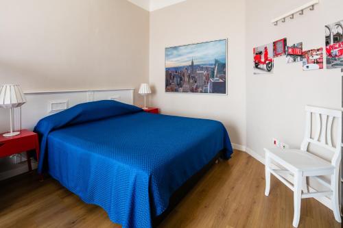 a bedroom with a blue bed and a white chair at Culture Residence Consalvo Otto in Naples