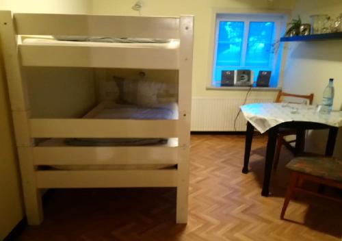 Etagenbett in einem Zimmer mit einem Tisch in der Unterkunft Ferienzimmervermietung Reitferien in Skærbæk