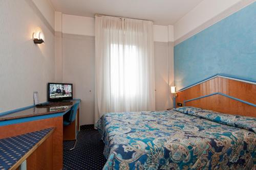 米蘭的住宿－麗都酒店，配有一张床和一张书桌的酒店客房