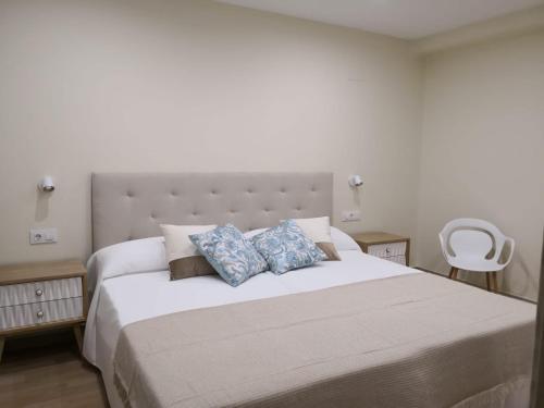 a bedroom with a large white bed with two pillows at A Torre do Lago in Valdoviño