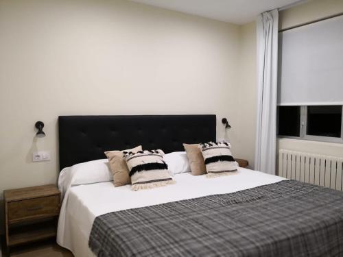 a bedroom with a large white bed with pillows at A Torre do Lago in Valdoviño