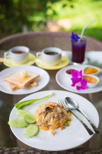 a table with plates of food and cups of coffee at Goldengold (Khaoyai) Resort & Spa in Mu Si