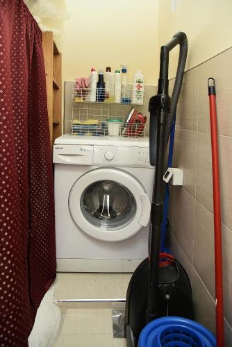 a mop and a washing machine in a bathroom at Vajda Apartments in Novi Sad