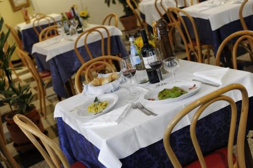 a table with plates of food and wine glasses at Hotel Bertusi in Porretta Terme