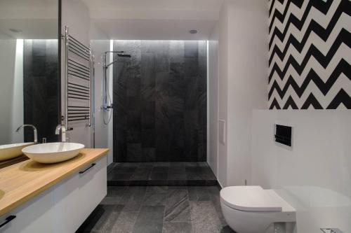 a bathroom with a shower and a toilet and a sink at Montevideo Centrum 15 by Grand Apartments in Sopot