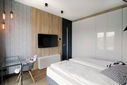 a bedroom with a bed and a tv on a wall at Montevideo Centrum 15 by Grand Apartments in Sopot