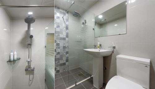 La salle de bains est pourvue de toilettes, d'un lavabo et d'une douche. dans l'établissement Gyeongpoen Pension, à Gangneung