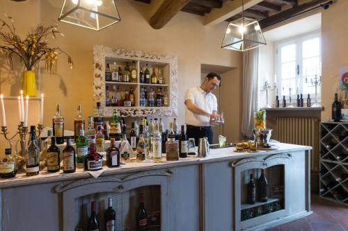 a man standing behind a bar with a lot of bottles at Hotel Albergo Villa Marta in Lucca