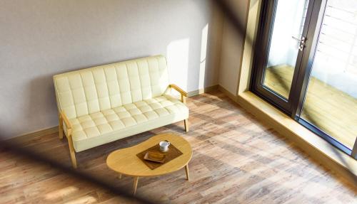 a living room with a white couch and a table at Gyeongpoen Pension in Gangneung