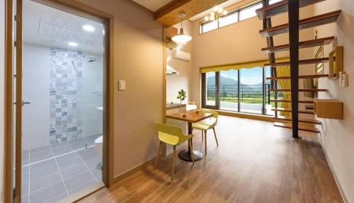 a room with a table and a bathroom with a shower at Gyeongpoen Pension in Gangneung