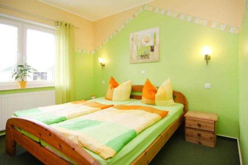 a bedroom with a large bed in a green room at Ferienhaus Albatros in Ostseebad Karlshagen