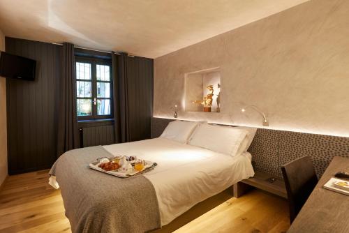 a hotel room with a bed with a tray of food on it at Locanda La Clusaz in Gignod