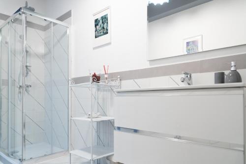 Baño blanco con cabina de ducha de cristal en Home 41°, en Formia