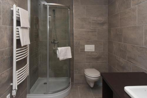 uma casa de banho com um chuveiro, um WC e um lavatório. em Oázis Wellness Panzio em Szigetszentmiklós