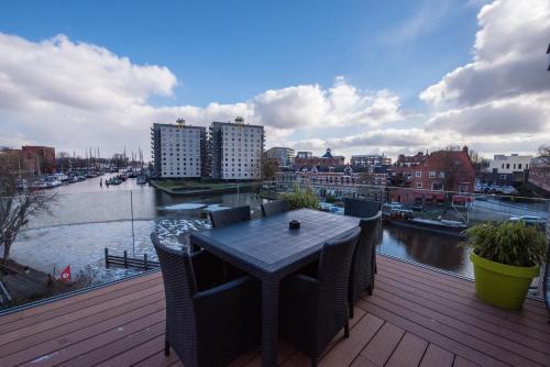 a table on a deck with a view of a river at Flonk Hotel Groningen Centre, BW Signature Collection in Groningen