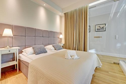 um quarto com 2 camas e uma grande cabeceira em Montevideo Centrum 4 by Grand Apartments em Sopot