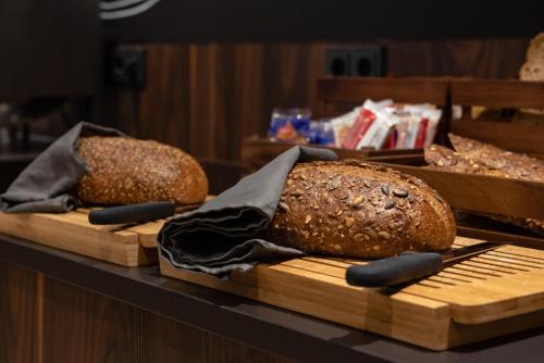 two loaves of bread sitting on wooden cutting boards at Flonk Hotel Groningen Centre, BW Signature Collection in Groningen