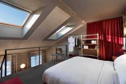 a bedroom with a bed and red curtains at Stories Boutique Hotel in Budapest