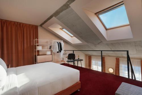 a bedroom with a large white bed and a window at Stories Boutique Hotel in Budapest