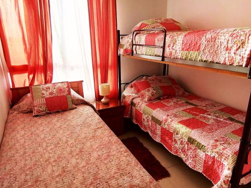 een slaapkamer met 2 stapelbedden en een raam bij Muy buena vista y ubicación in Coquimbo