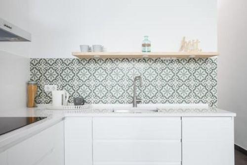 a kitchen with a sink and a green tile wall at Stylish Apartment with Terrace for Couple or Family in Barcelona