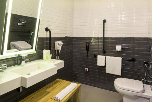 a bathroom with a sink and a toilet and a mirror at Novotel Sao Paulo Morumbi in Sao Paulo